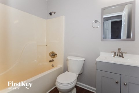 a bathroom with a toilet and a tub and a sink