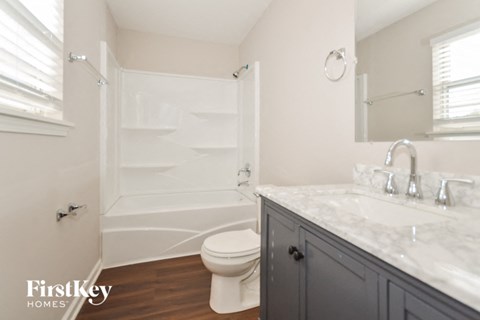 a bathroom with a toilet and a sink and a shower