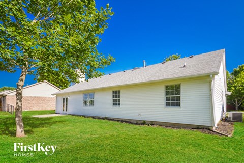 a small white house with a tree in front of it