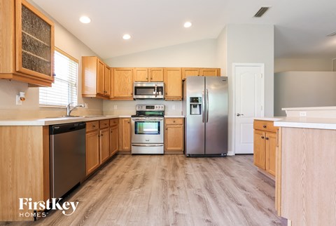 A kitchen with wooden cabinets and a refrigerator.