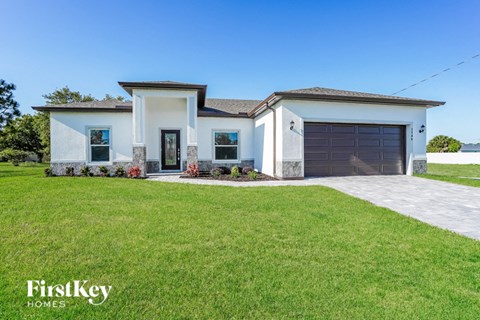 a house with a lawn and a driveway and a garage door