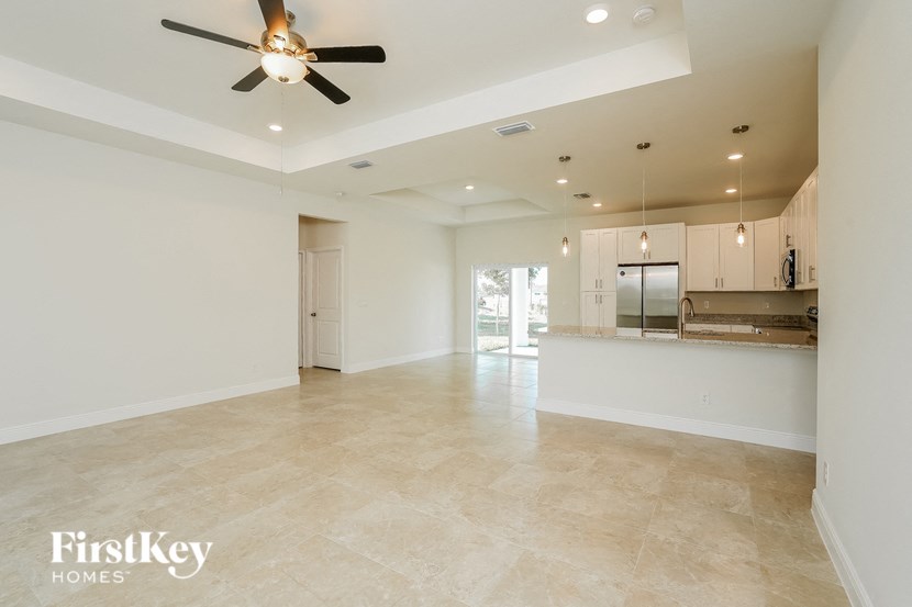 an empty kitchen and living room with a ceiling fan