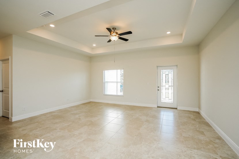 an empty living room with a ceiling fan