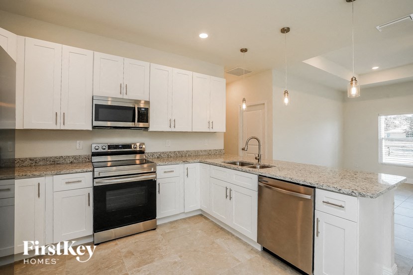 a kitchen with white cabinets and stainless steel appliances and granite counter tops