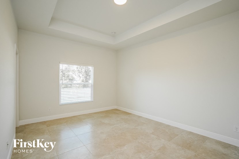 an empty living room with white walls and a window