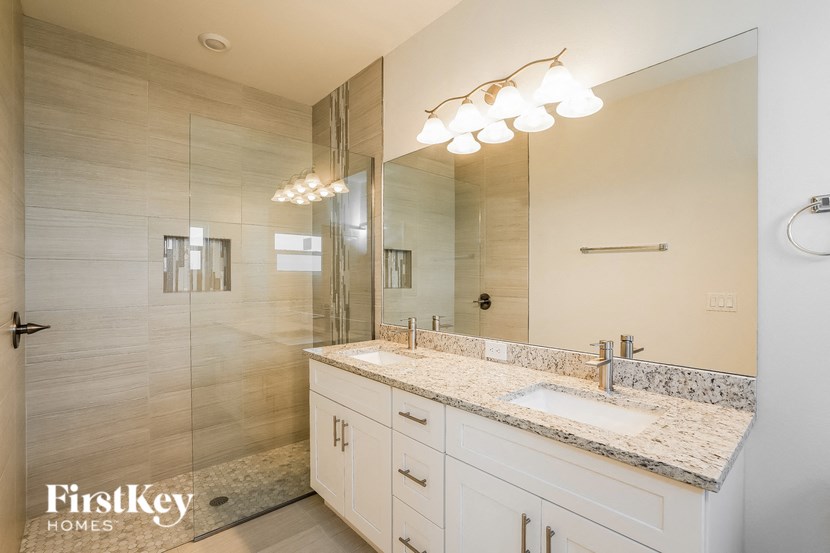 a bathroom with a sink and a shower and a mirror