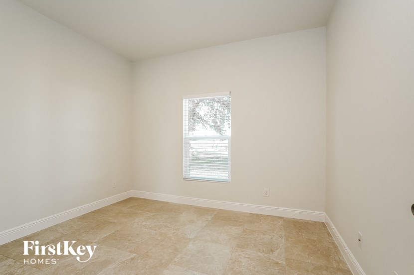 a empty room with a window and tiled floors