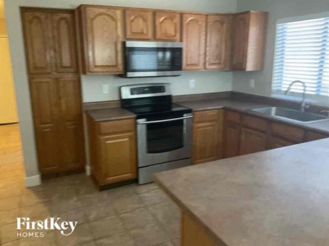 A kitchen with wooden cabinets and a stainless steel oven.