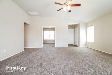 a living room with carpet and a ceiling fan