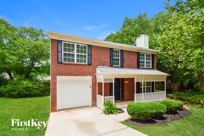 a brick house with a white garage door and a porch