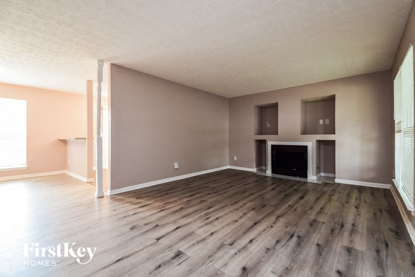 an empty living room with wood floors and a fireplace