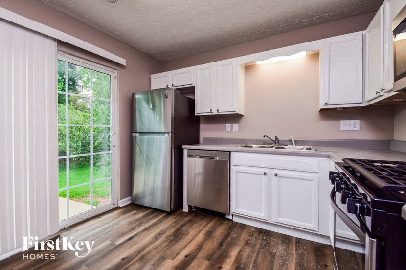 a kitchen with white cabinets and a stainless steel refrigerator