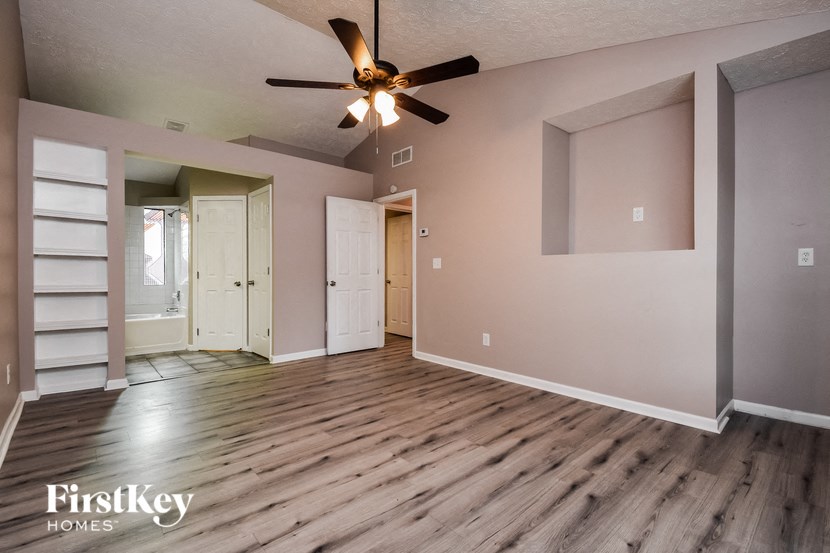 the living room of an empty house with a ceiling fan