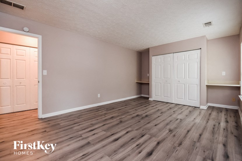 the living room of an empty house with wood flooring and two doors