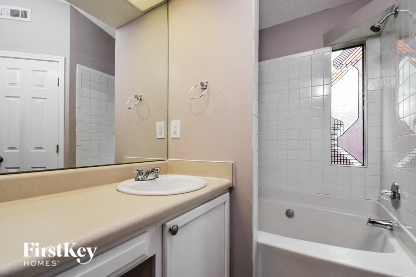 a bathroom with a sink and a tub and a mirror