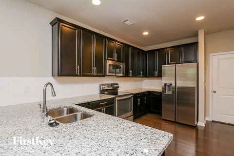 A kitchen with a sink and a refrigerator.