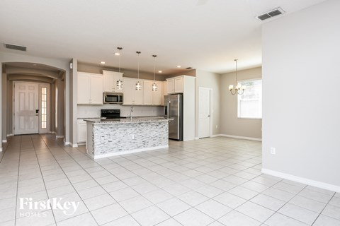 a large kitchen with white cabinets and a marble counter top