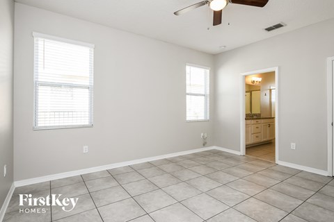 a living room with a tile floor and a ceiling fan
