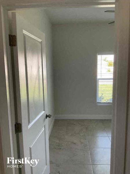 an empty room with a white door and a window