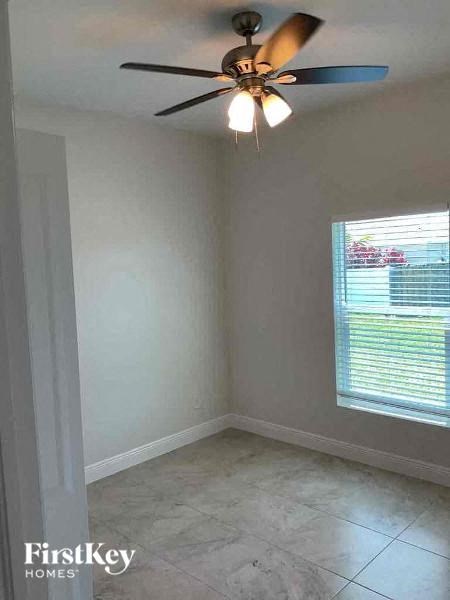 an empty room with a ceiling fan and a window