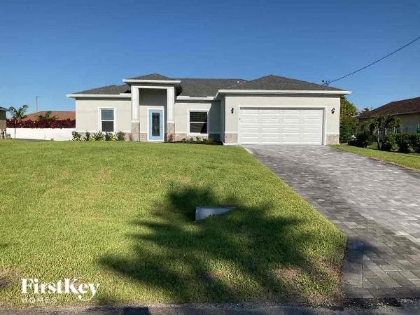 a house with a driveway and lawn in front of it