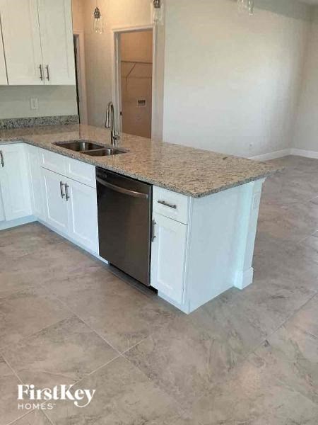 a kitchen with white cabinets and a granite counter top