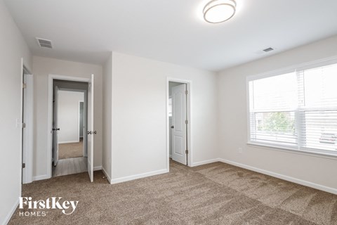 a living room with a carpeted floor and a large window