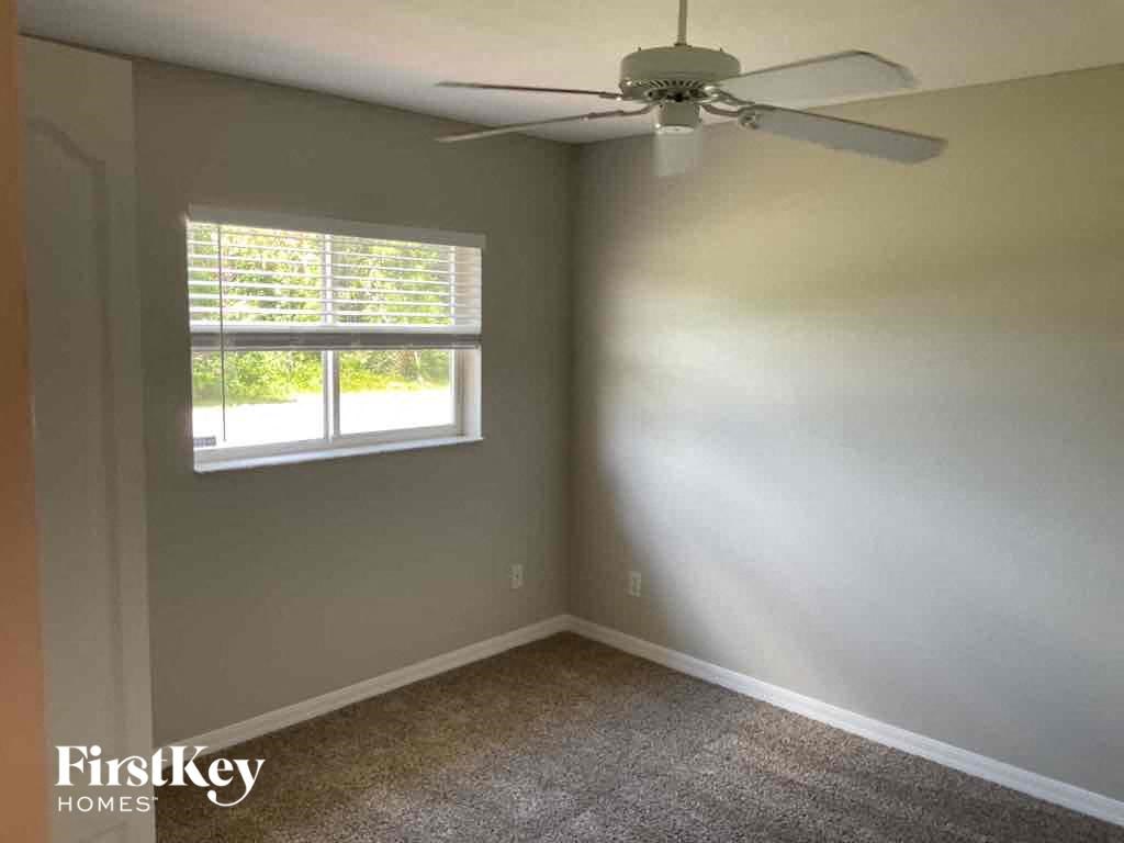 an empty room with a ceiling fan and a window