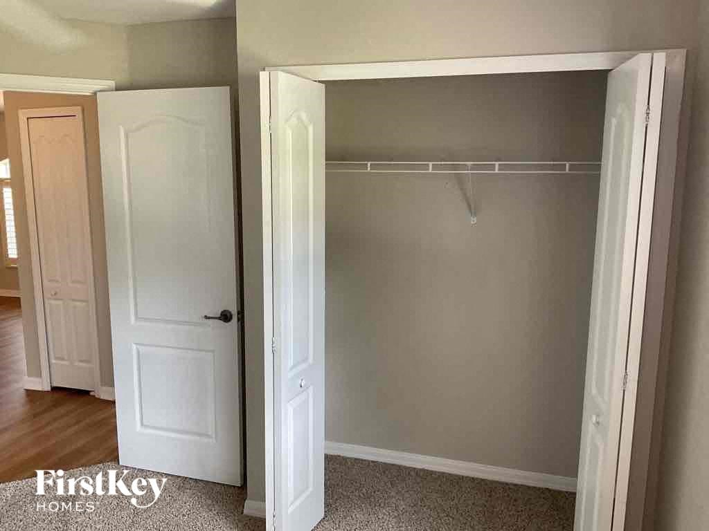 a walk in closet in a bedroom with a white closet door