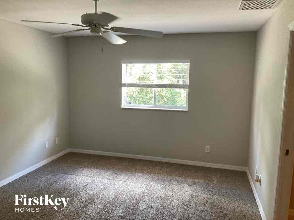 an empty room with a ceiling fan and a window