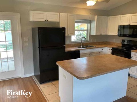 a kitchen with a counter top and a black refrigerator