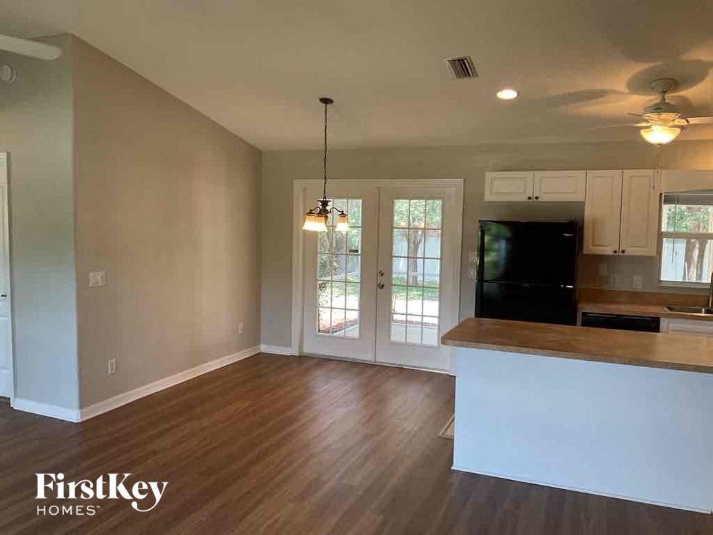 an empty kitchen and living room with a door to a patio