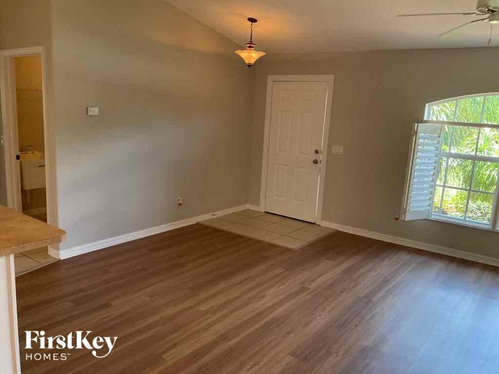 an empty living room with wooden floors and a white door
