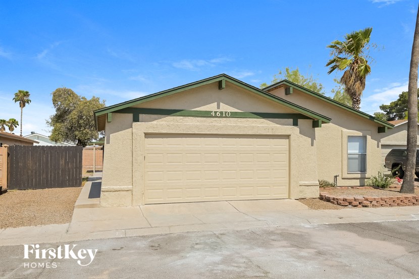 a garage door in front of a house with a palm tree