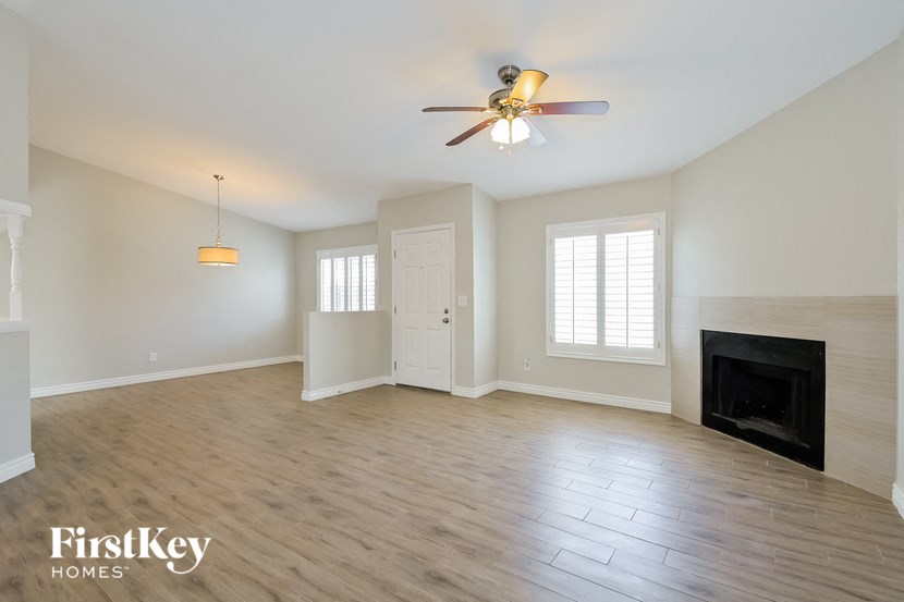 a living room with a fireplace and a ceiling fan