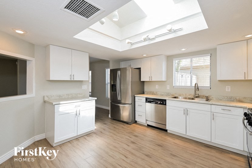 a kitchen with white cabinets and stainless steel appliances