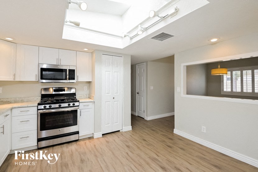 an empty kitchen with white cabinets and stainless steel appliances