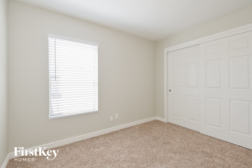 a bedroom with a white door and a carpeted floor