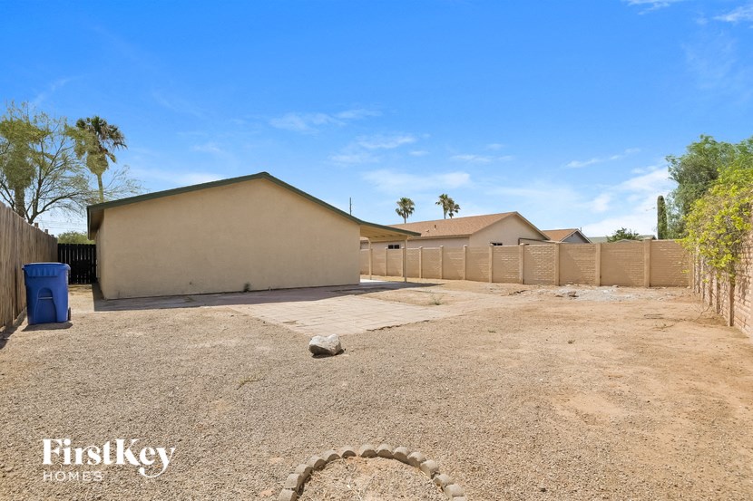 the backyard of a home with a dirt lot and a fence