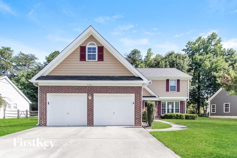 a brick house with a white garage door in front of a lawn