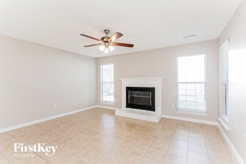 a living room with a fireplace and a ceiling fan