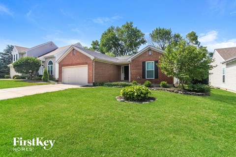 a brick house with a lawn and a white garage door