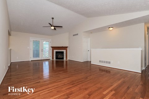 the living room with hardwood floors and a fireplace