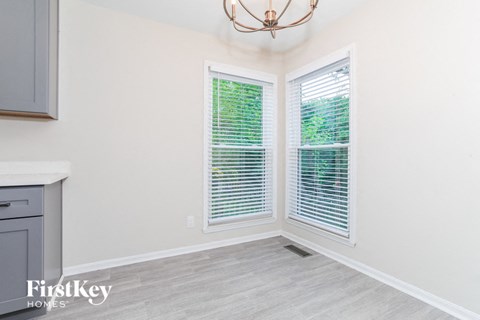 the living room of a home with two windows and a kitchen