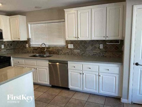 A kitchen with white cabinets and a FirstKey sign.