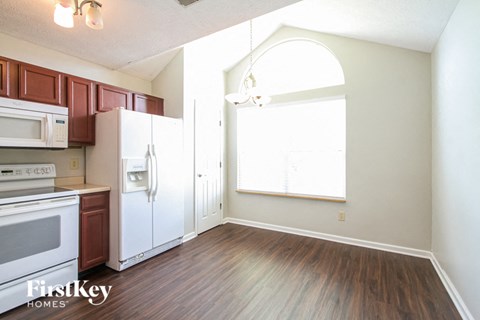 A kitchen with a white fridge and brown cabinets.