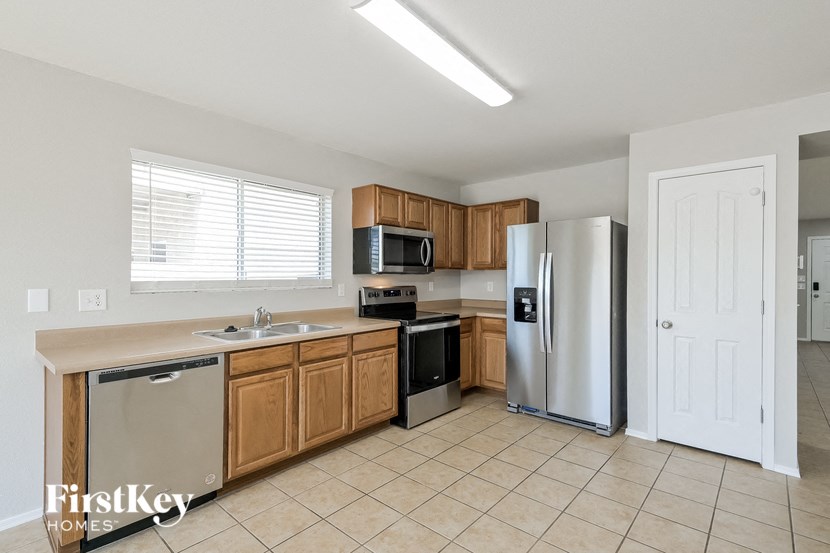 A kitchen with a refrigerator, sink, and oven.