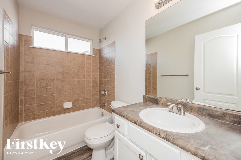 A bathroom with a tub, toilet, and sink.
