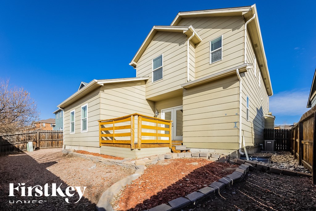 A two-story house with a yellow fence in front.