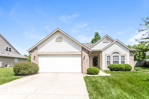 A two-story house with a garage and a driveway.